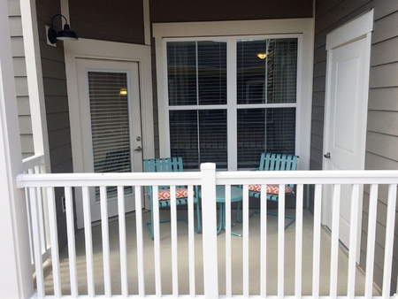Patio with railing and door to storage.