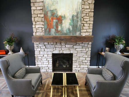 Clubhouse seating area with two chairs in front of a fireplace.