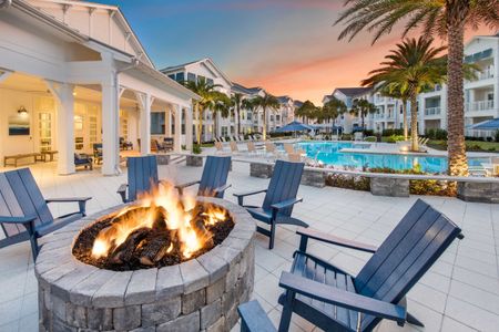 poolside lit fire pit with apartment buildings at dusk