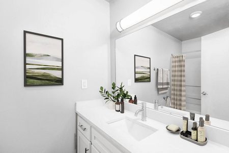 Bellevue Apartments - Newly Renovated Bathroom with Upgraded Modern Lighting, Large Mirror, White Countertops, And Shower With Tub.