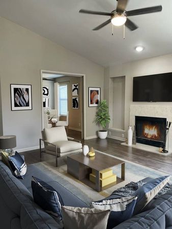 Dog-Friendly Apartments in Hermitage, TN - Highlands at the Lake - Living Room with Lighted Ceiling Fan, Fireplace, Faux Wood Grain Flooring, and Stylish Decor
