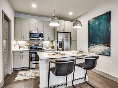 Upgraded kitchen with quartz countertops at Midway Urban Village Luxury Townhomes and loft apartments in Farmers Branch, Texas near North Dallas. Luxury North Dallas Townhomes for rent