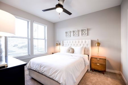 Pet Friendly Apartments in Nashville TN - The Sound at Pennington Bend - A Bedroom With A Full Size Bed Next To Two Large Windows Letting Plenty Of Light Into The Carpeted Room Complete With A Ceiling Fan/Light