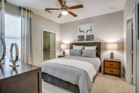 Large bedroom with carpet flooring, natural light, ceiling fan
