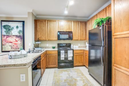 Full black appliance package includes dishwasher, microwave, refrigerator and stove. Also, included is a built- in desk and tile flooring.
