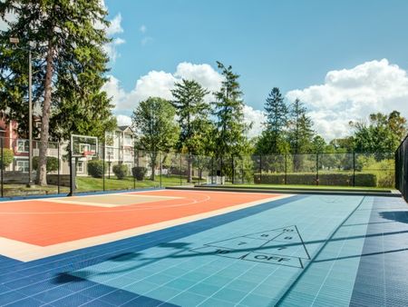 Tennis court with apartment structure in the background.