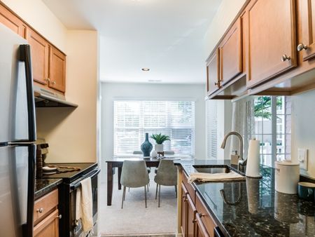 Interior view of apartment kitchen, upgraded with stainless steel appliances and granite counter-tops.