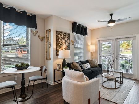 The Sound at Pennington Bend - Stylish Living Room With Modern Furniture, a Ceiling Fan, and Several Tall Windows with Blinds