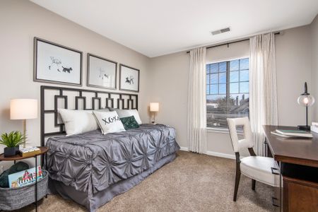 Furnished model bedroom with office desk and golf course view from the oversized bay windows