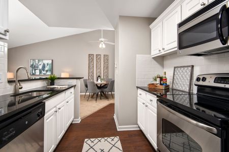 Model kitchen with granite countertops, ceramic tile backsplash and stainless steel appliances