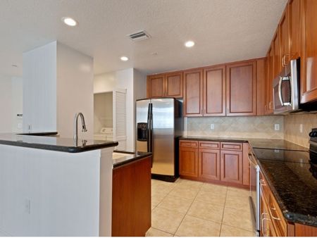 Kitchen with cabinets, refrigerator, sink, stainless steel refrigerator, microwave, and oven