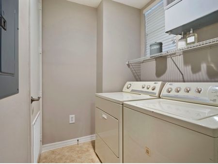 Laundry room with full-sized, side-by-side washer and dryer with shelving above