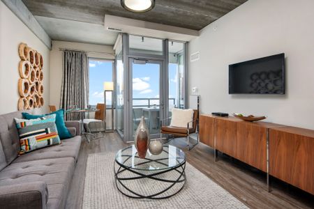 Furnished living room with a flat-screen TV, vinyl plank flooring and a balcony view
