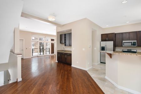 Tiled kitchen and dining room area with vinyl plank flooring for a three bedroom floor plan