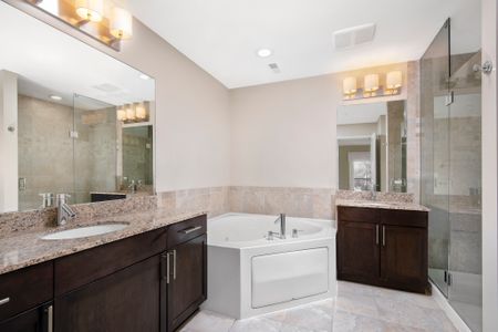 Master bathroom with granite countertops, double bowl stainless steel sinks and a soaker tub