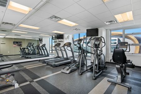 Downtown Milwaukee, WI Apartments For Rent - The Moderne - Fitness Center With Cardio Equipment, Mirror, And TV.