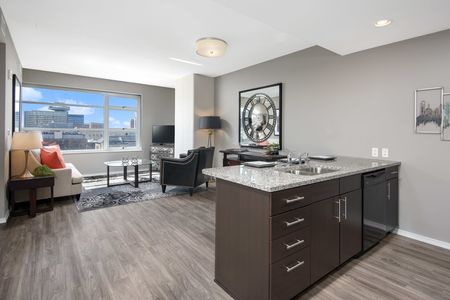 Furnished model living room with a city view and kitchen island