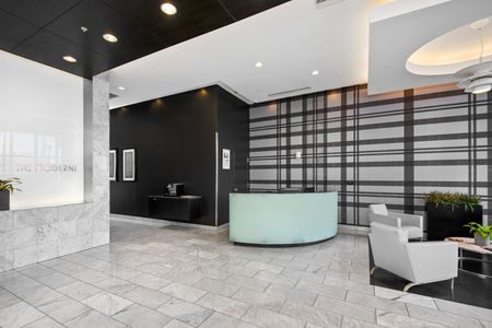One-Bedroom Apartments in Downtown Milwaukee, WI - The Moderne - Sophisticated Lobby With Chairs, Coffee Table, Front Desk, And Mail Boxes.