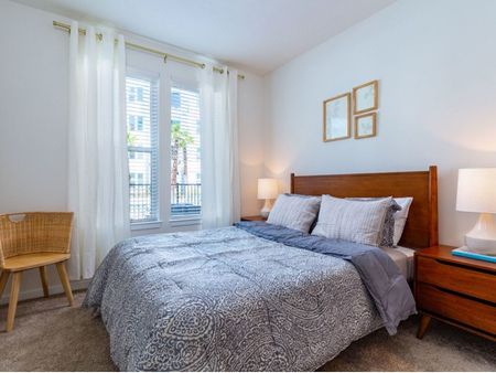 m2 at millenia bedroom with double window, queen size bed with end tables