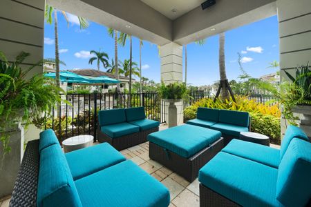Plush outdoor seating with pool view and open cabana covering