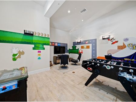 Game room with video game wall art, foosball table, video games and console lounge