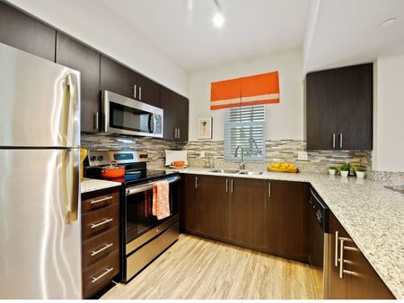 Kitchen with back splash and stainless steel refrigerator, microwave, and oven