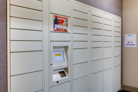 White parcel locker system with touchscreen and keypad to retrieve packages