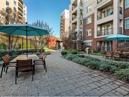Outdoor patio area with umbrella shaded tables and seating  | The Rocca Apartments in Atlanta, GA