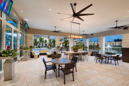 Top covered open-air lounge with ceiling fans, TV, view to pool area, and comfortable seating