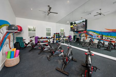 Spin room with stationary bikes, kettle bells, balls, mirrored wall and TV