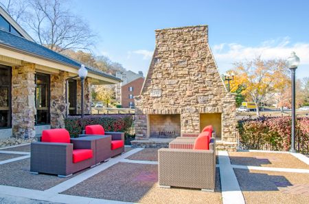 Pet-Friendly Apartments In Bellevue - Cozy Outdoor Fireplace With Four Chairs, Outdoor Lighting, And Plants.
