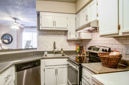 Apartments Near Bellevue - Kitchen With Stainless Steel Appliances, Modern White Wood Cabinets, Tile Back Splash, Refrigerator, And Dishwasher.