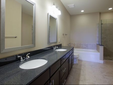 Classical bathroom with tile flooring and double sinks and mirrors  | The Rocca Apartments in Atlanta, GA