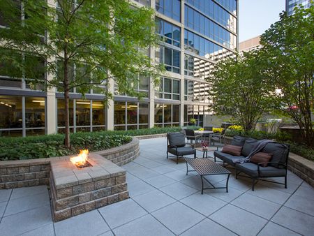 Outdoor lounge and firepit area with trees and tables and chairs