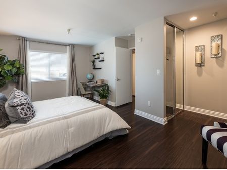 bedroom with wood-inspired plank flooring and mirrored sliding closet doors at the warwick