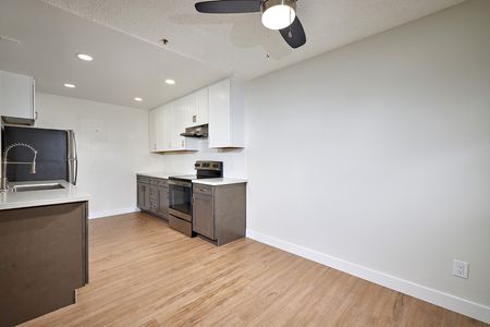 renovated kitchen with stainless steel appliances, updated cabinets and countertops, and dining room