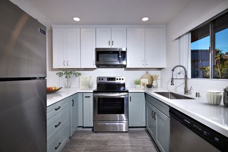 Virtually staged kitchen with updated appliances, cabinets, flooring and countertops
