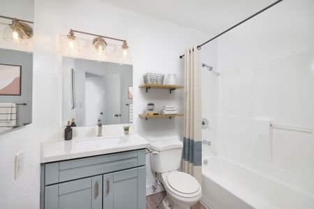 Virtually staged updated bathroom with shower, tub combo and energy efficient lighting, and eco friendly toilet