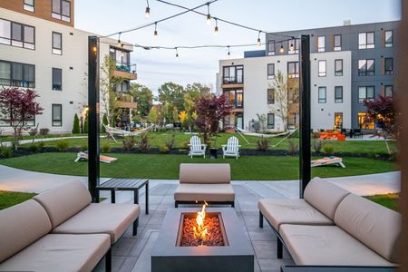 Courtyard with fire feature and seating with hammock garden in background at West End Yards | Portsmouth Apartments