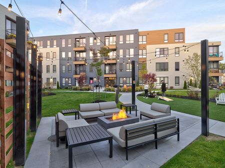 Outdoor patio with fire feature surrounded by seating at West End Yards | Apartments In Portsmouth, NH for Rent
