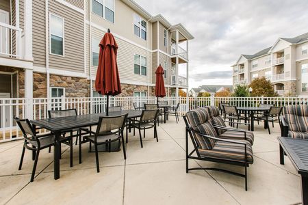 Sun deck with umbrella shaded tables near pool | The View at Mill Run | Apartments in Owings Mills, MD for Rent