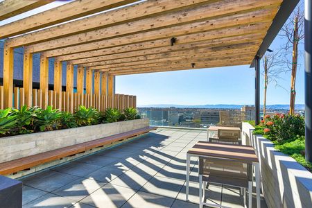 Apartments for Rent in Oakland - Eleven Fifty Clay Rooftop Patio Lounge with Ample Seating, Fire Pit, and Stunning City Views