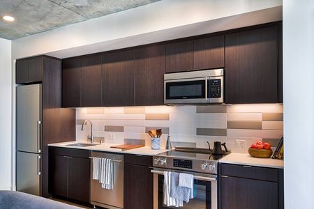 Apartments Oakland - Eleven Fifty Clay Kitchen with Sleek Stainless Steel Appliances, Designer Cabinetry, and Modern Backsplash