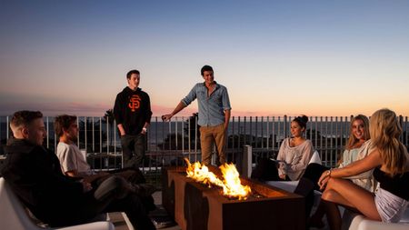 Students sitting by outdoor firepit