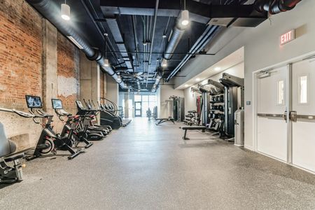 fitness center with workout equipment like treadmills and free weights