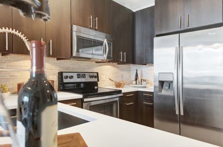 Open-concept gourmet kitchens with solid slab granite and quartzite countertops, stainless steel appliances and full-height backsplashes
