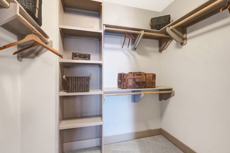 Walk-in closet with built-in shelves and closet rods across three walls