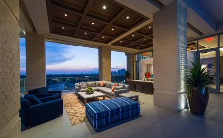 Outdoor lounge with skyline views, gray and blue couch and table area.