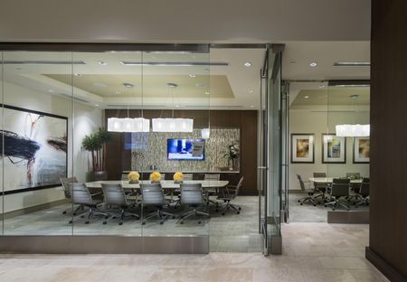 Two glass-walled conference rooms, one with a 10-person table, leather rolling office chairs, and HD presentation TV.