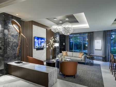 Seating area with a 60-inch HDTV, large windows and modern, abstract sculptures.